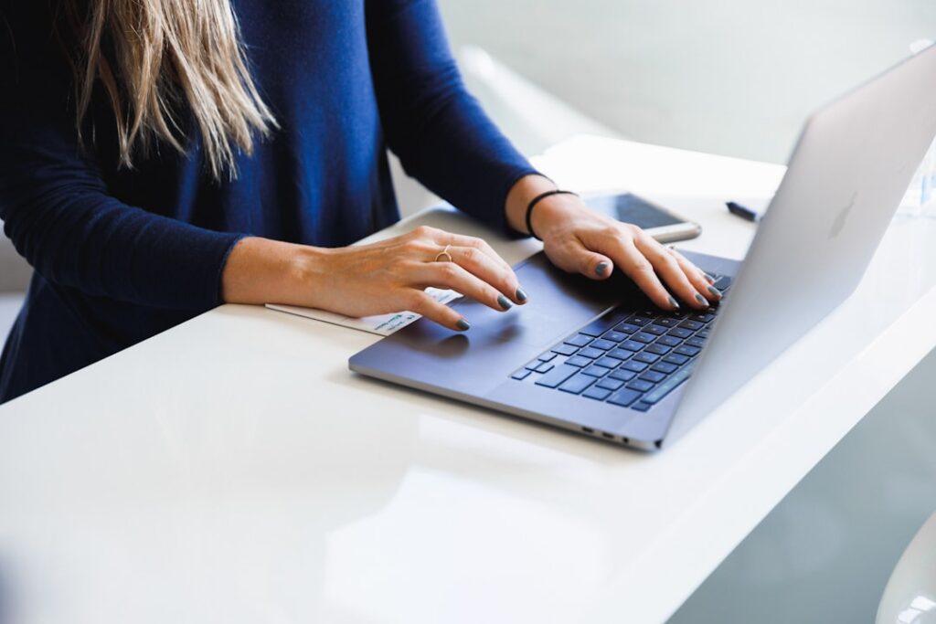 Mulher usando notebook em ambiente de trabalho, representando agente de viagens usando ferramentas de IA