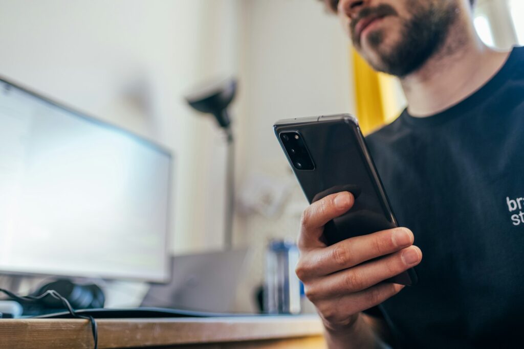 Pessoa segurando o celular para responder mensagens de clientes pelo WhatsApp Business