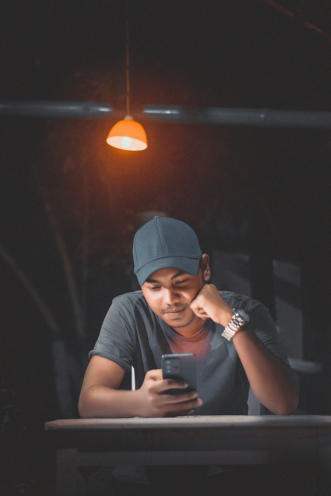 Homem olhando o celular, checando mensagens de clientes