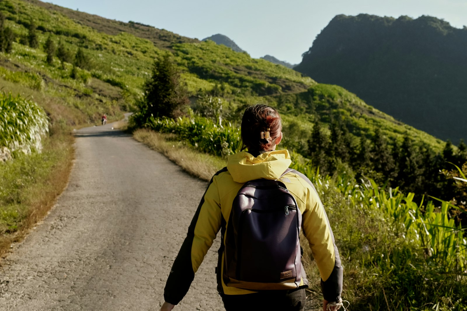 Viajante com mochila observando um vale nas montanhas, longe dos roteiros mais óbvios