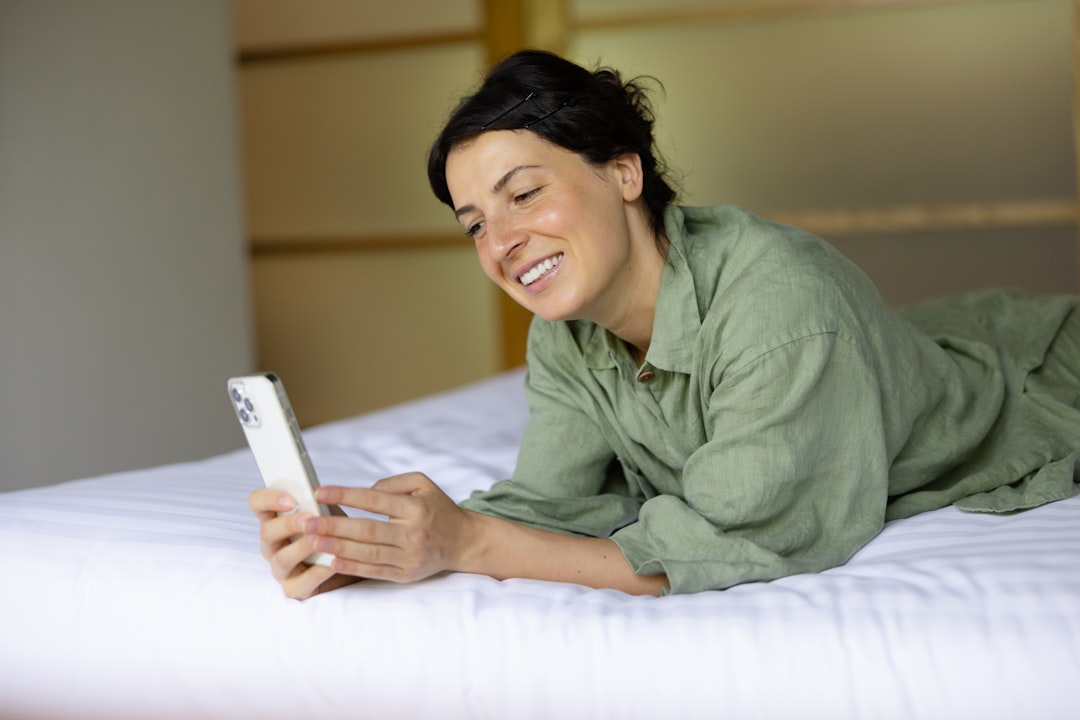Pessoa deitada usando o celular à noite, pesquisando opções de viagem