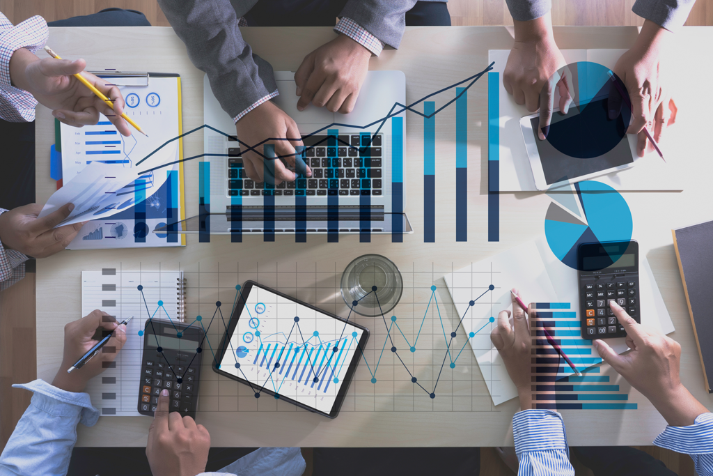 Equipe analisando dashboard de vendas com gráficos de crescimento sobre a mesa