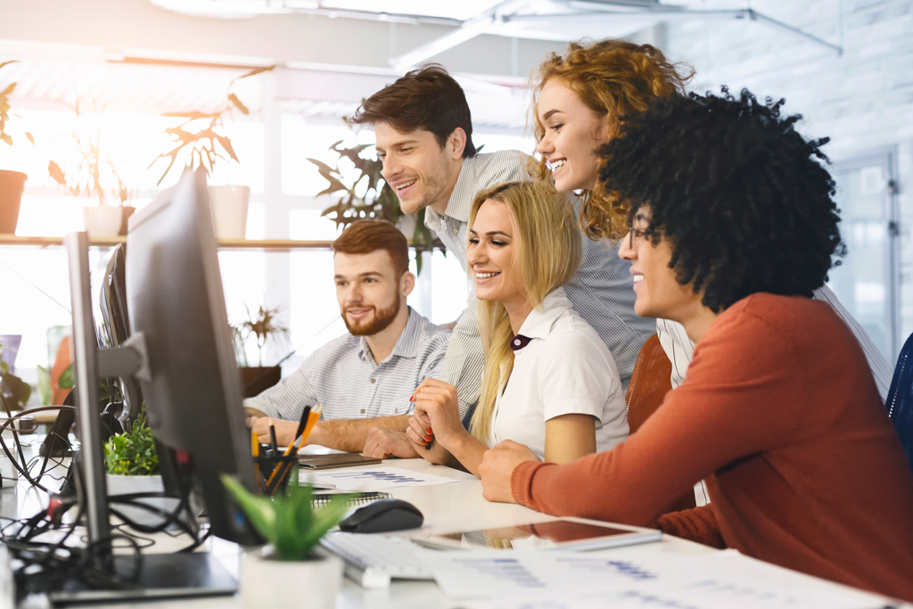 Equipe de agência de viagens analisando dados de IA em uma tela de computador