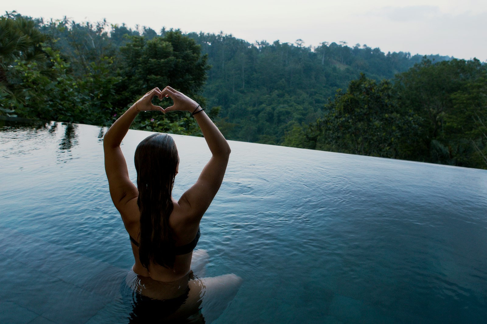 Piscina tranquila cercada de vegetação usada para meditação, representando experiências de bem-estar em viagens