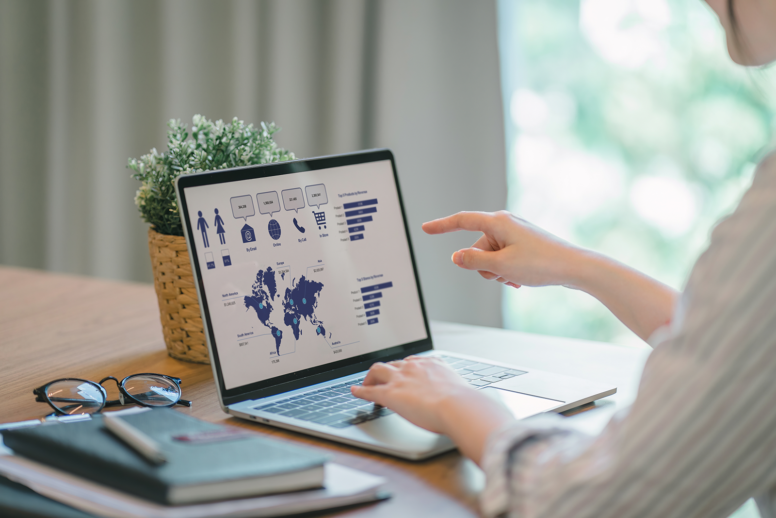 Mulher aponta para gráficos de um dashboard de CRM em um laptop, organizando dados de leads e oportunidades