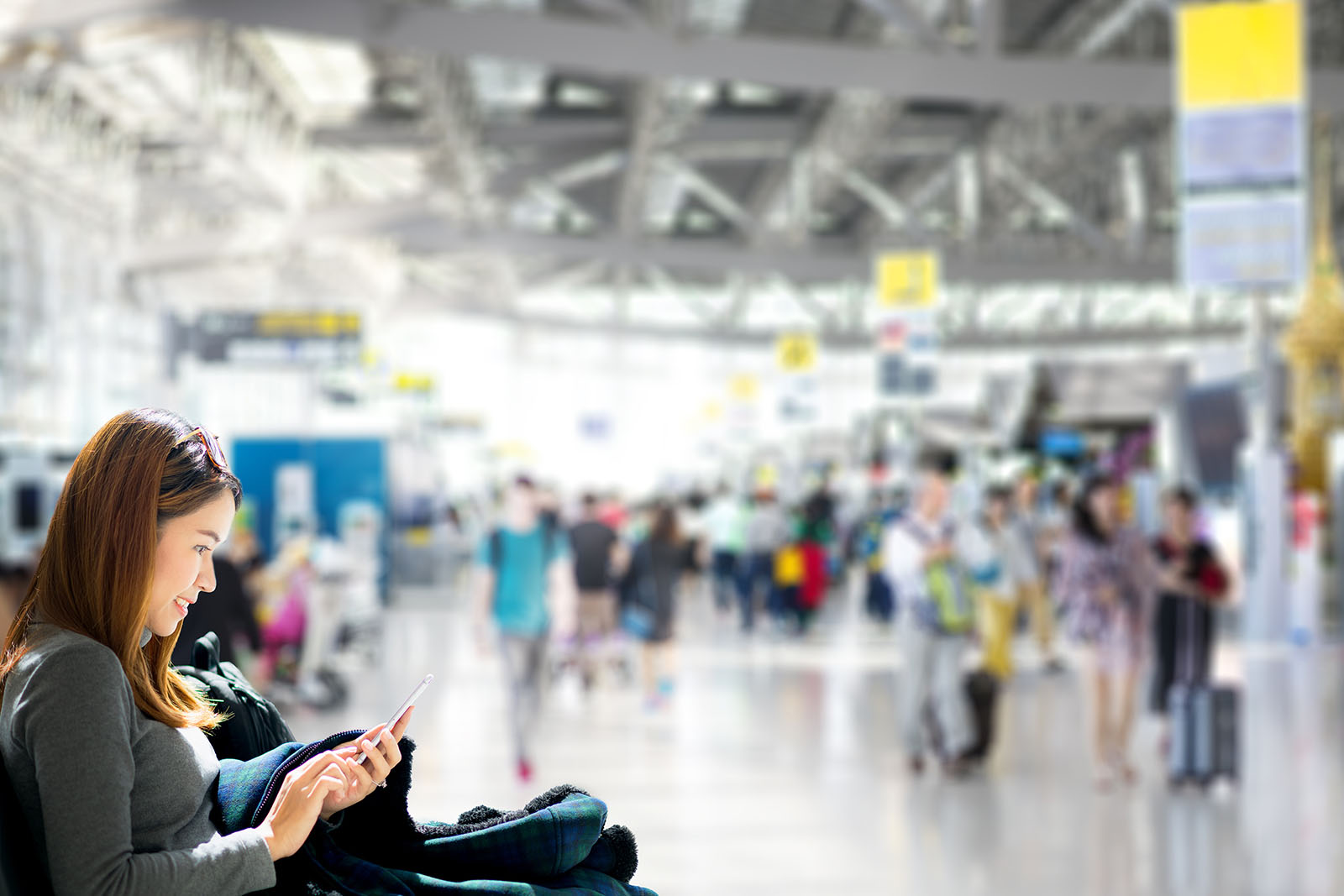 Viajante conferindo o celular no aeroporto pouco antes do embarque