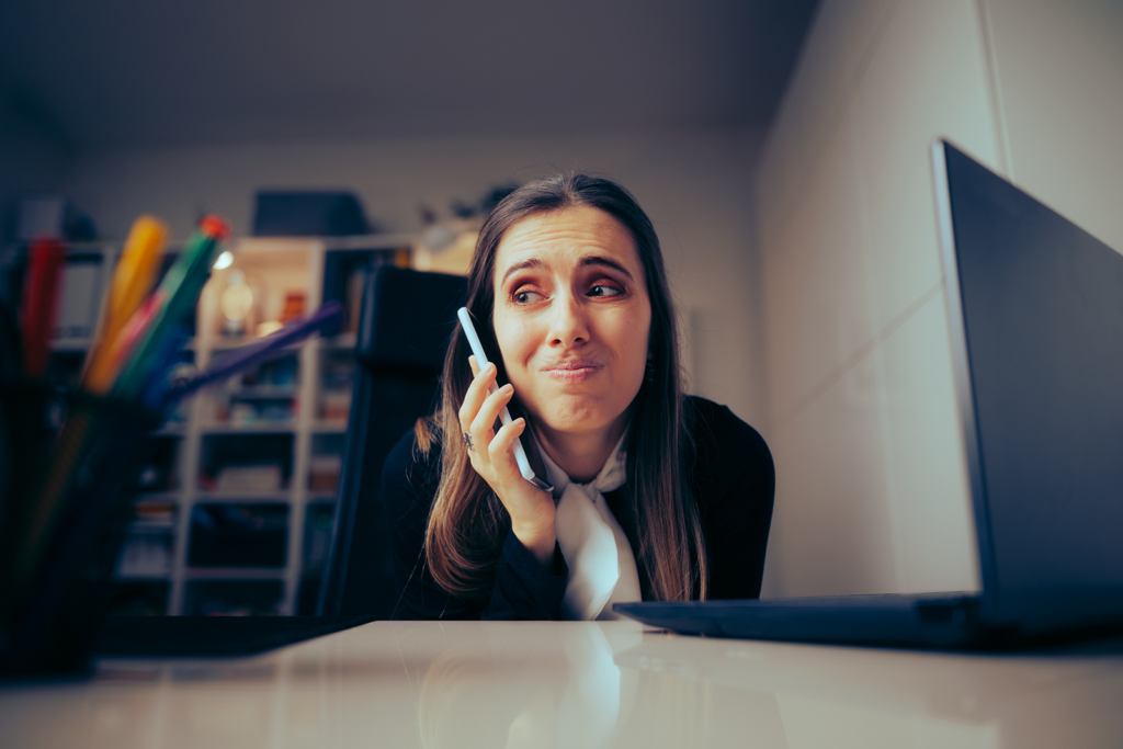 Vendedora de agência de viagens sobrecarregada ao telefone, cercada de anotações, tentando lembrar detalhes de um lead sem sistema centralizado