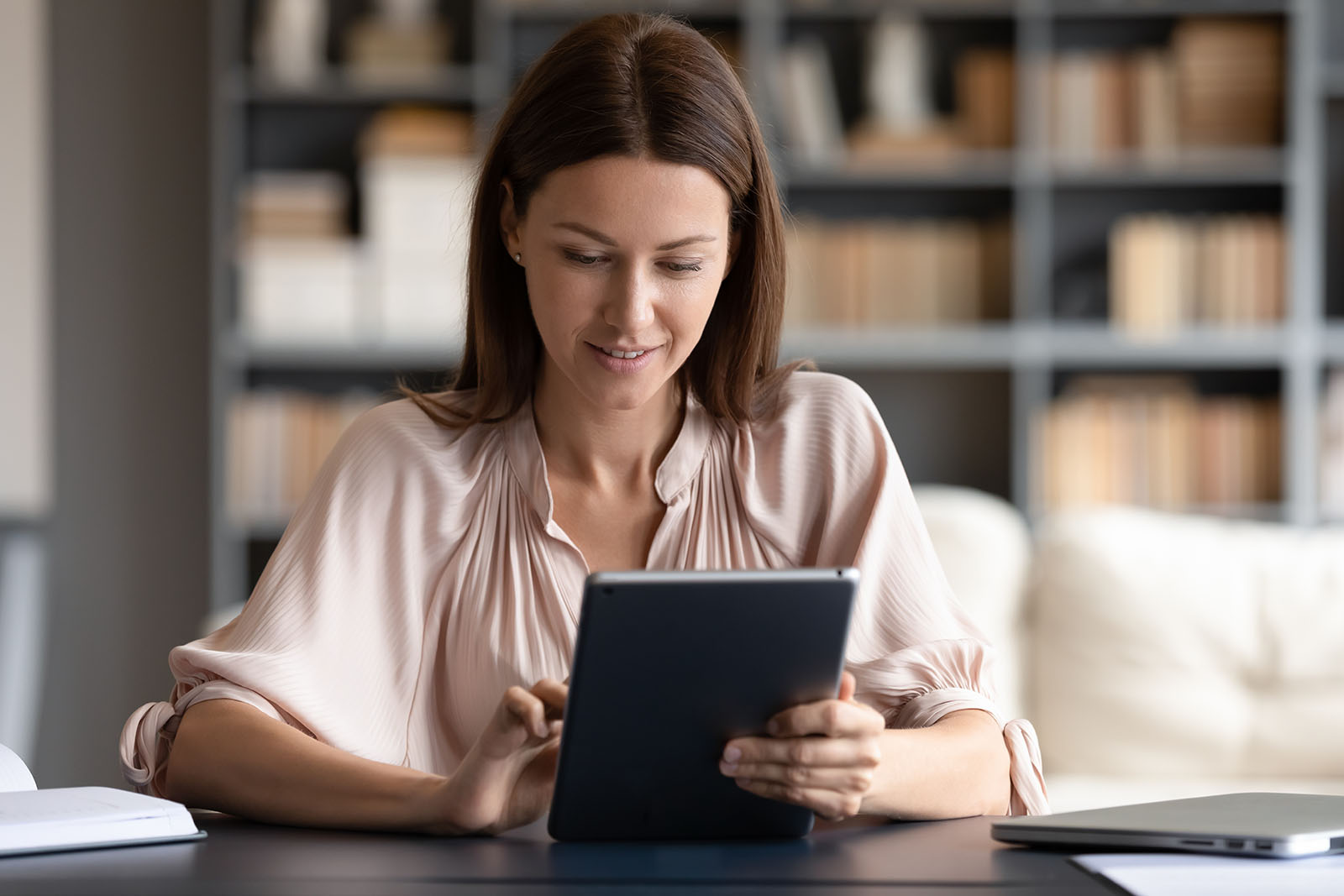 Pessoa conferindo em um tablet uma lista de perguntas frequentes de um site de viagens