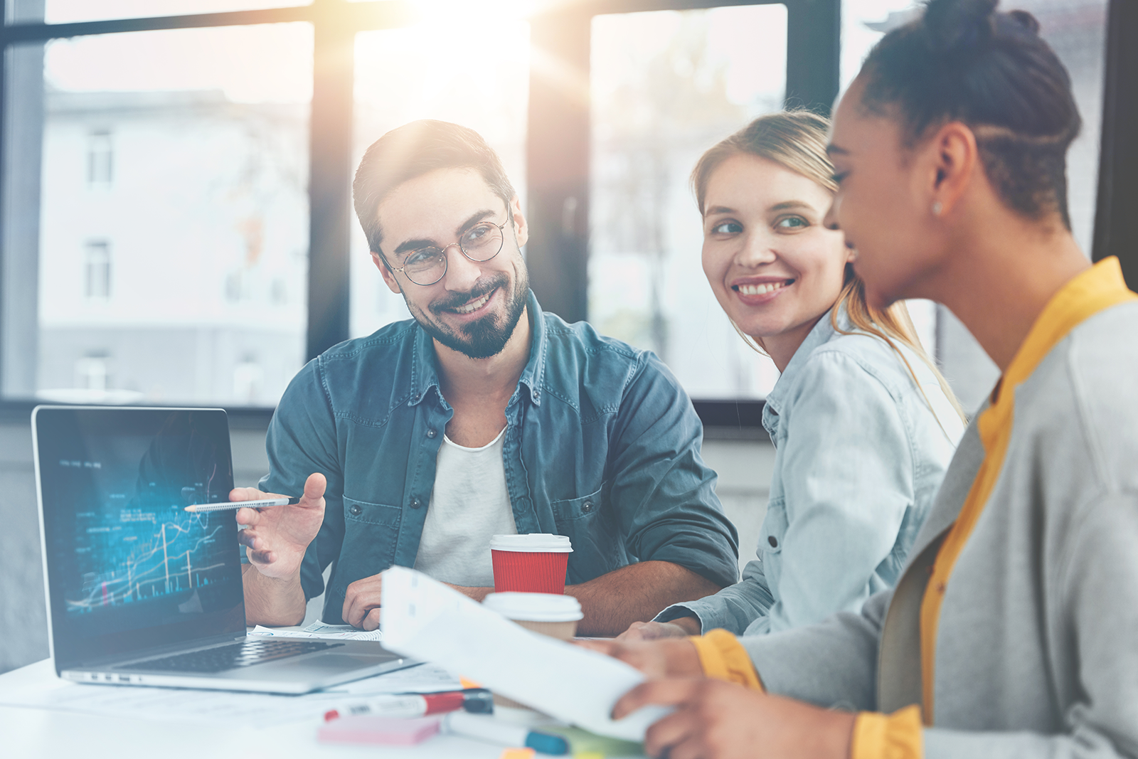Equipe de vendas analisando gráfico de prioridade de leads em um laptop durante reunião