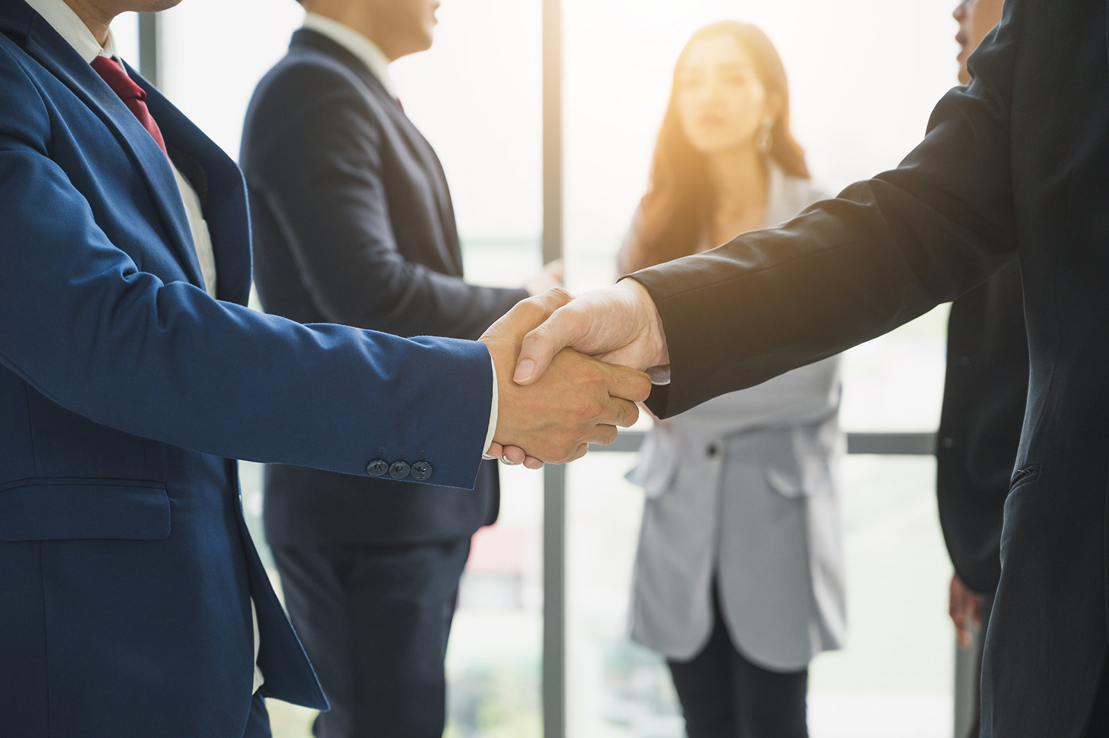 Executivos apertam as mãos selando acordo de aquisição empresarial em escritório
