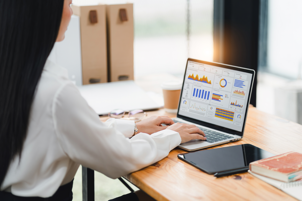 Profissional de vendas analisando dashboard de CRM com gráficos de funil de vendas em laptop